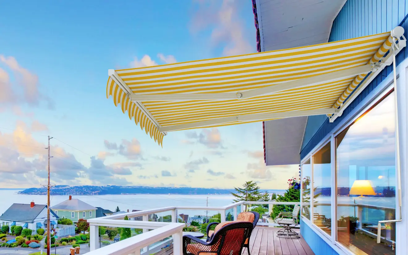 Markise auf Terrasse mit Blick auf Meer und Häuser im Hintergrund