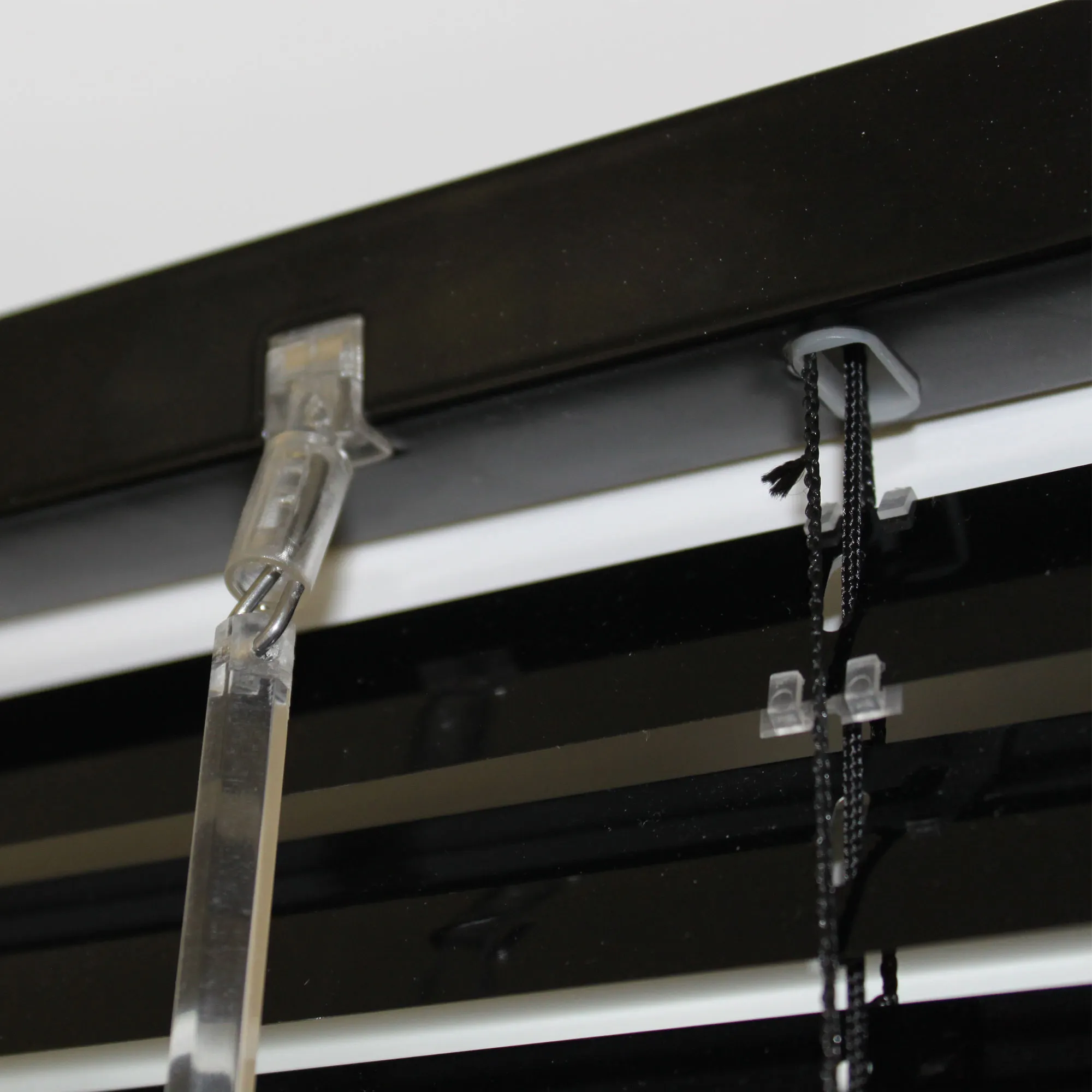 Veneziana con bastone in acrilico e corde per il funzionamento delle lamelle in alluminio