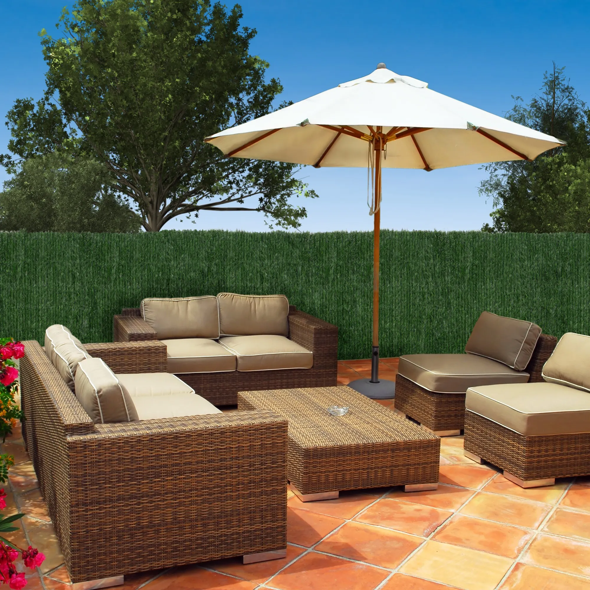 Terrazza con mobili e siepe artificiale come brise-vue sullo sfondo