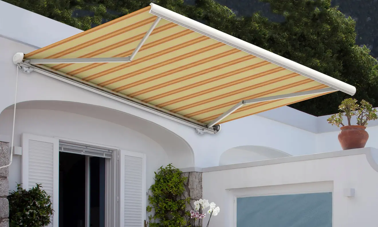 Kassettenmarkise Curve 2000 über einer Terrasse, bietet Sonnenschutz und ist an der Wand montiert