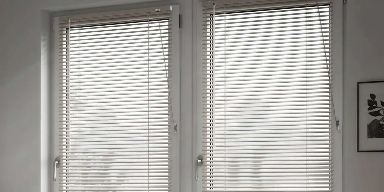 Zwei Fenster mit hellen Jalousien, geschlossene Lamellen und integrierte Kindersicherung