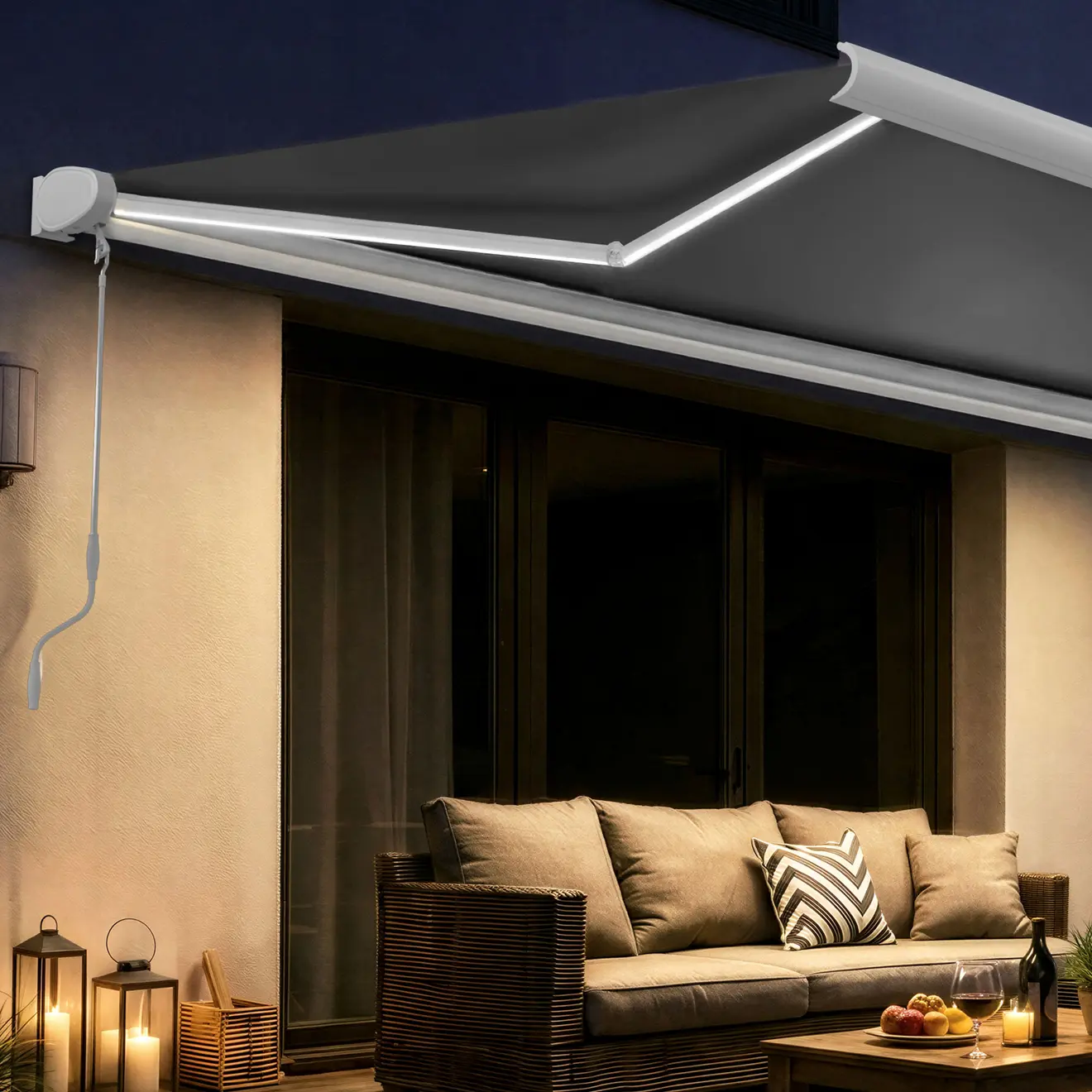 Ausgefahrene Terrassenmarkise über einer abendlichen, beleuchteten Sitzlounge