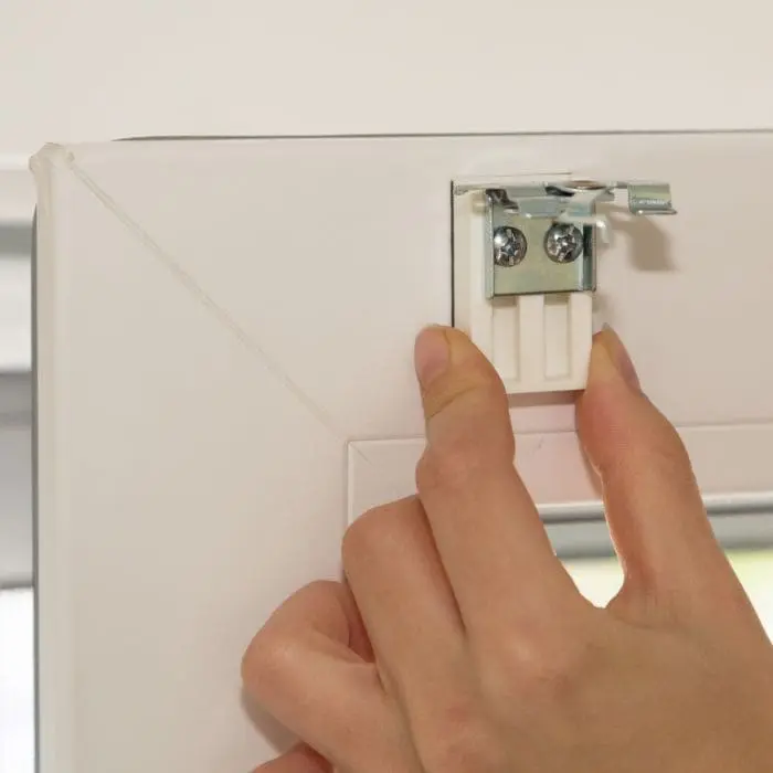 Hand befestigt Universal Haftträger an einem Rahmen, zwei Schrauben sichtbar