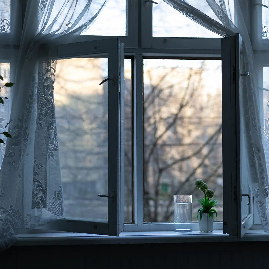 Offenes Fenster bei Abendstimmung. Insektenschutz hält Insekten ab.