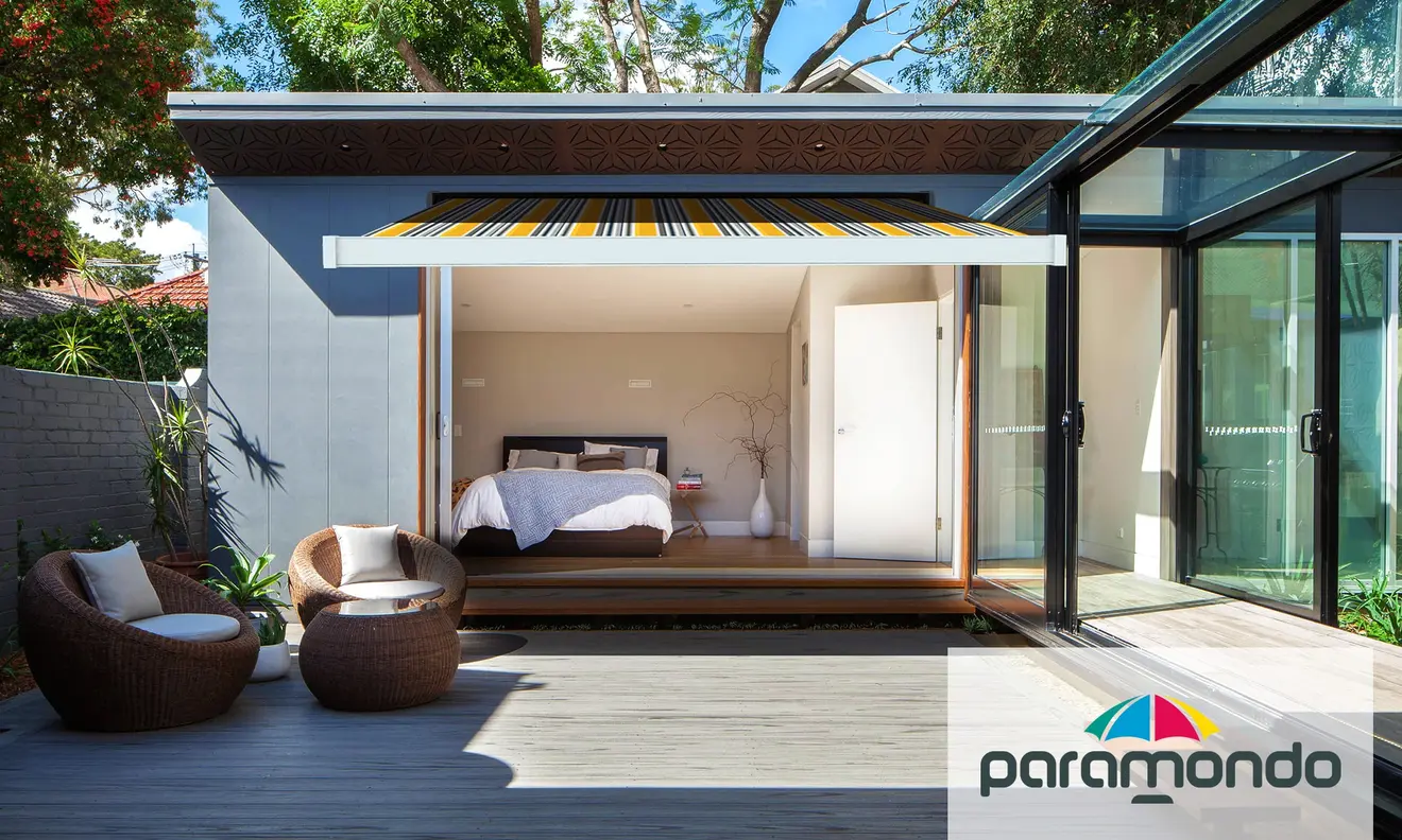 Kassettenmarkise Line über einer Terrasse vor einem modernen Gebäude mit Glasfront