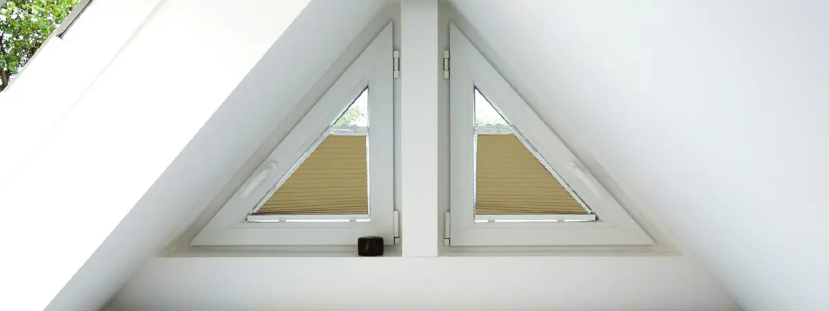 Zwei dreieckige Fenster mit maßgefertigten Plissees im Dachgeschossbereich