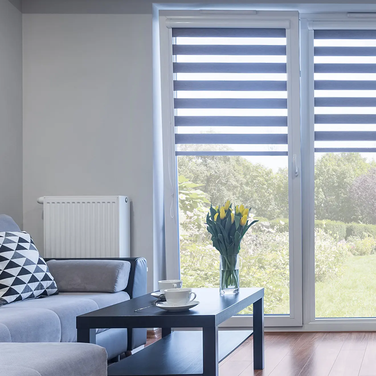 Elektrisches Smart Doppelrollo an Fenster in modernem Wohnzimmer mit Sofa und Tisch