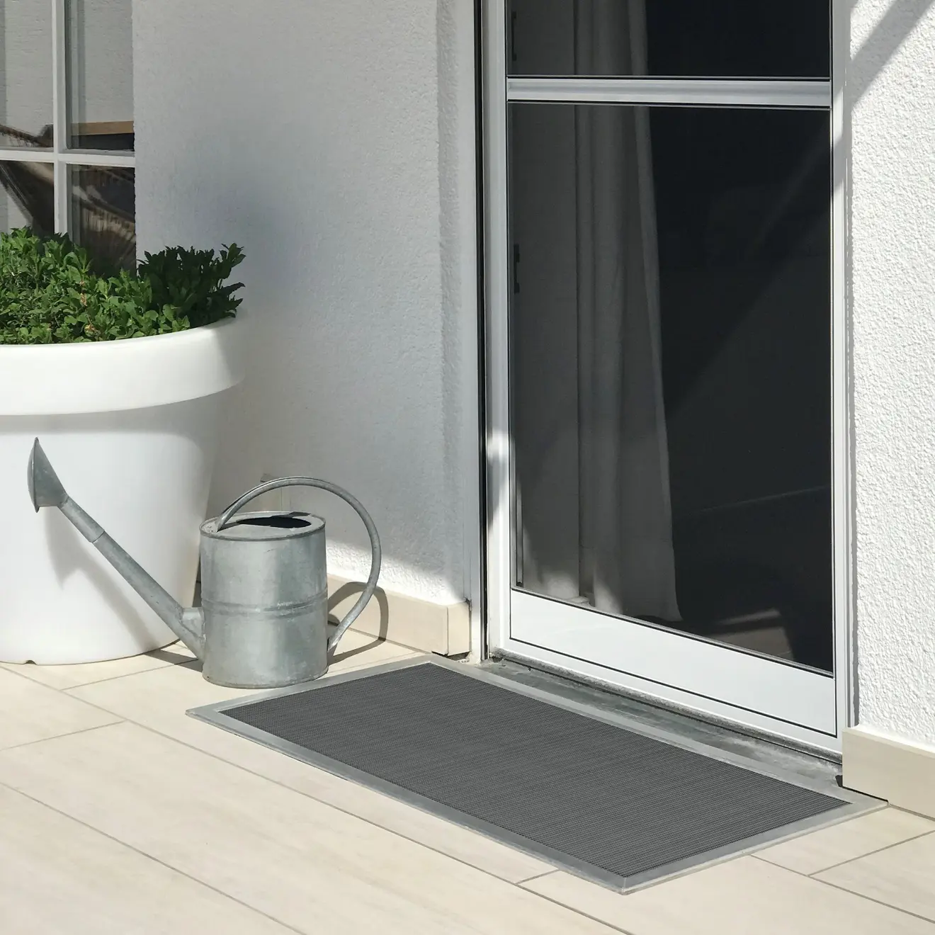 Pokrywa nasłonecznika na jasnym tarasie przed drzwiami, z konewką i donicą