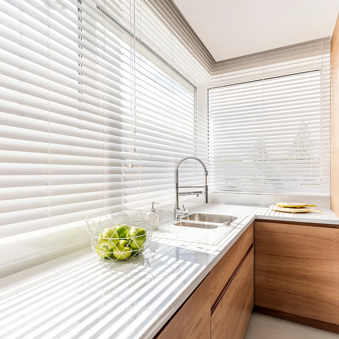 Jalousie an Fernstern von lichtdurchfluteter Küche