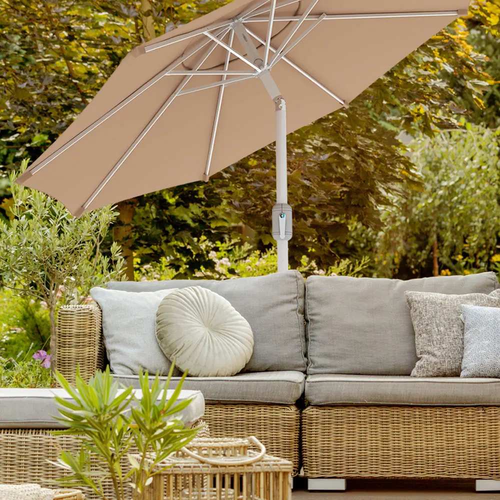 Sonnenschirm über Outdoor‑Sofa in Garten mit Pflanzen und Holzterrasse