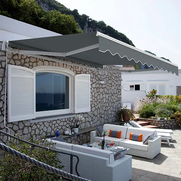 Markise über einer Terrasse mit Sitzbereich und Pflanzen im Hintergrund