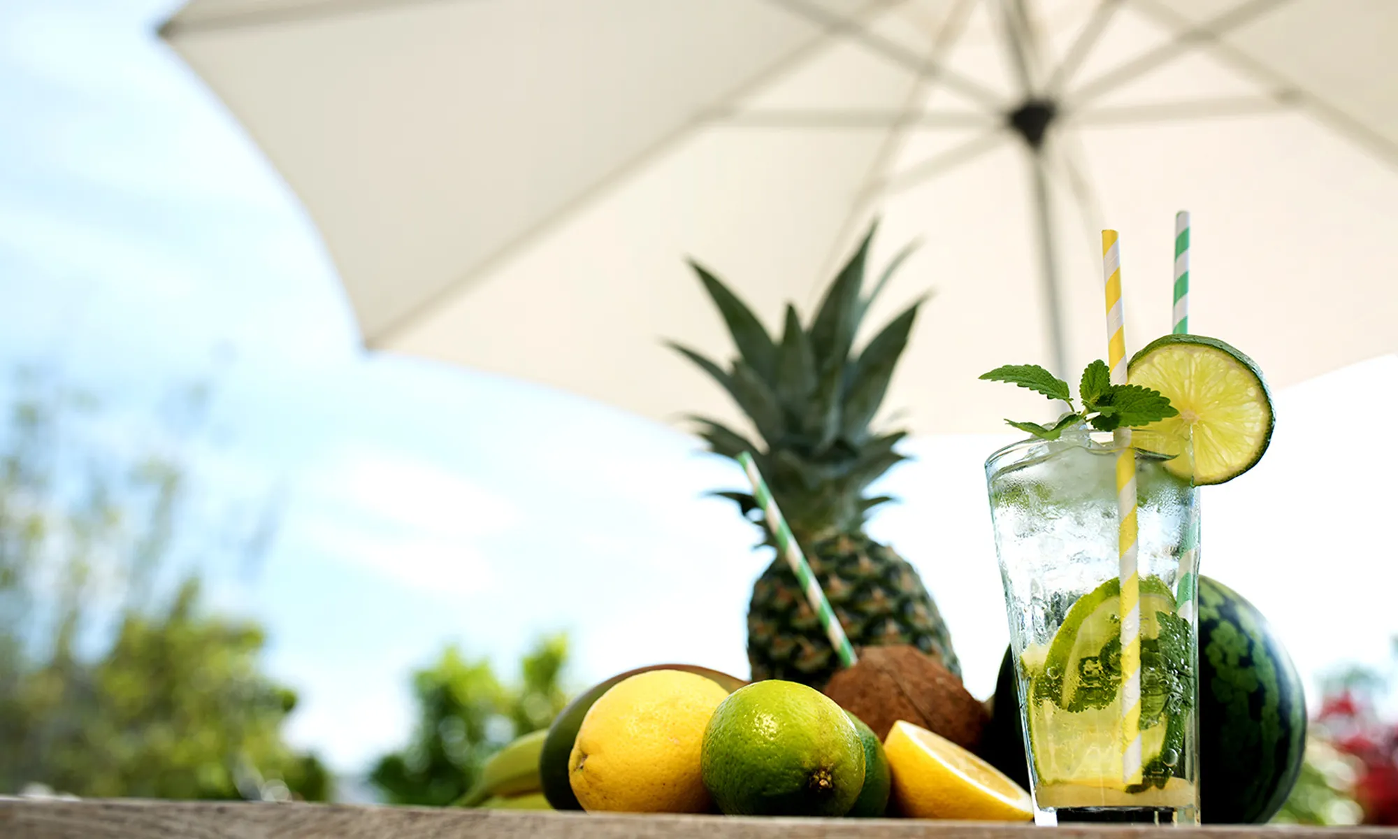 Bevanda e frutta su un tavolo sotto un ombrellone