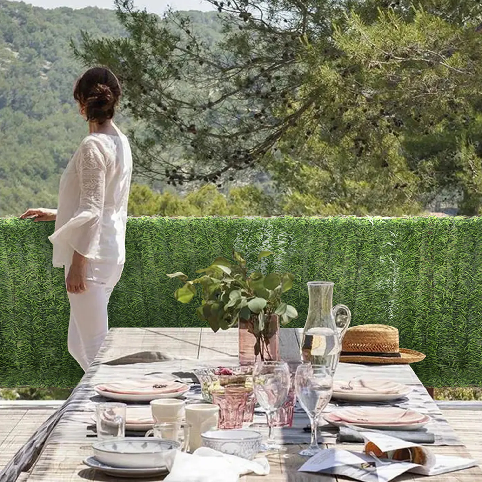 Persona su una terrazza con siepe artificiale come schermo per la privacy sullo sfondo
