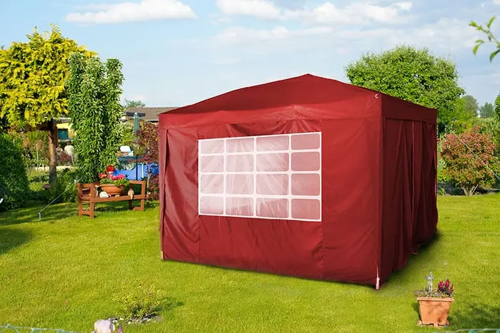 Pavillon mit Seitenteilen und Fenster auf einer Wiese im Freien