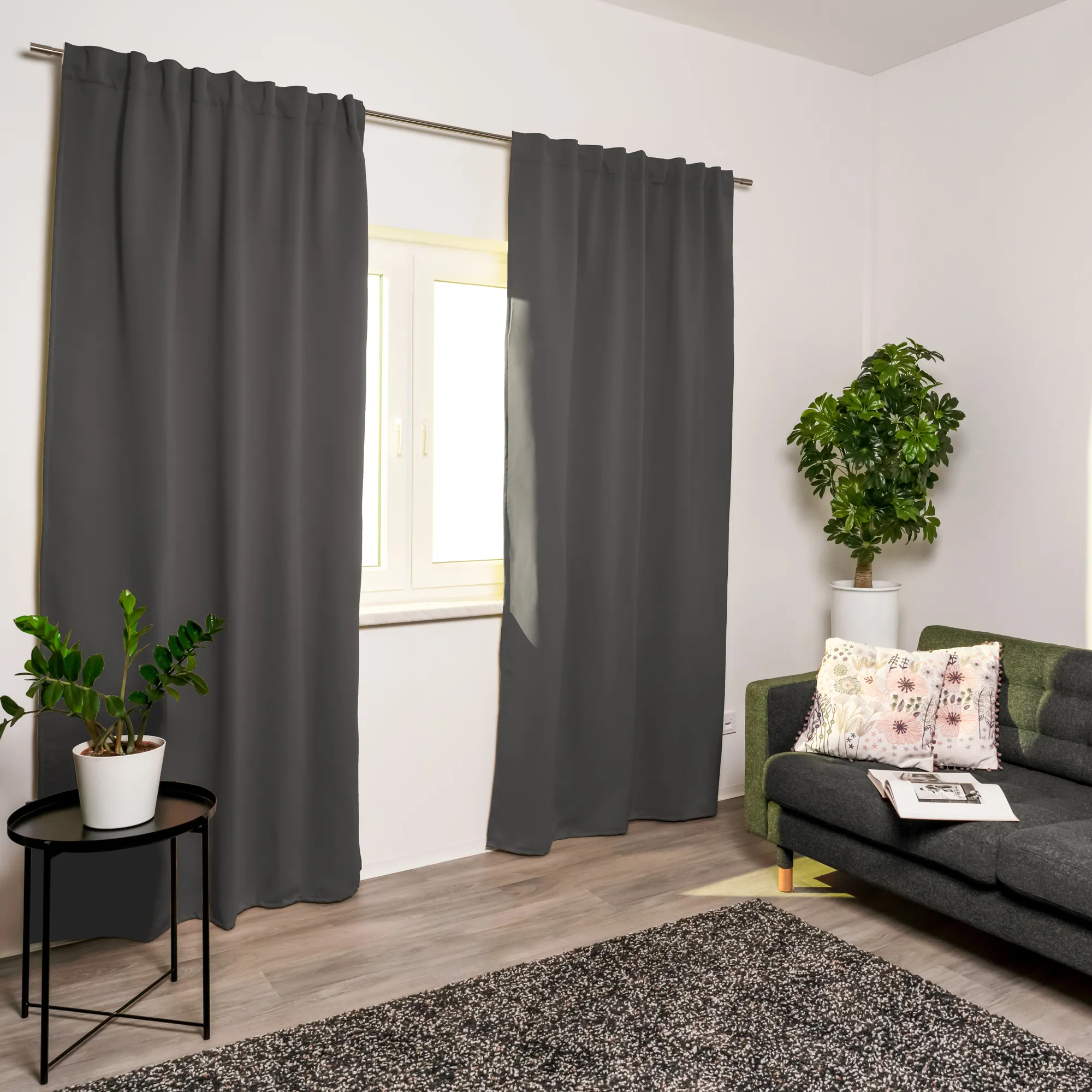 Tenda acustica con nastro combinato davanti a una finestra in un soggiorno moderno con piante e divano