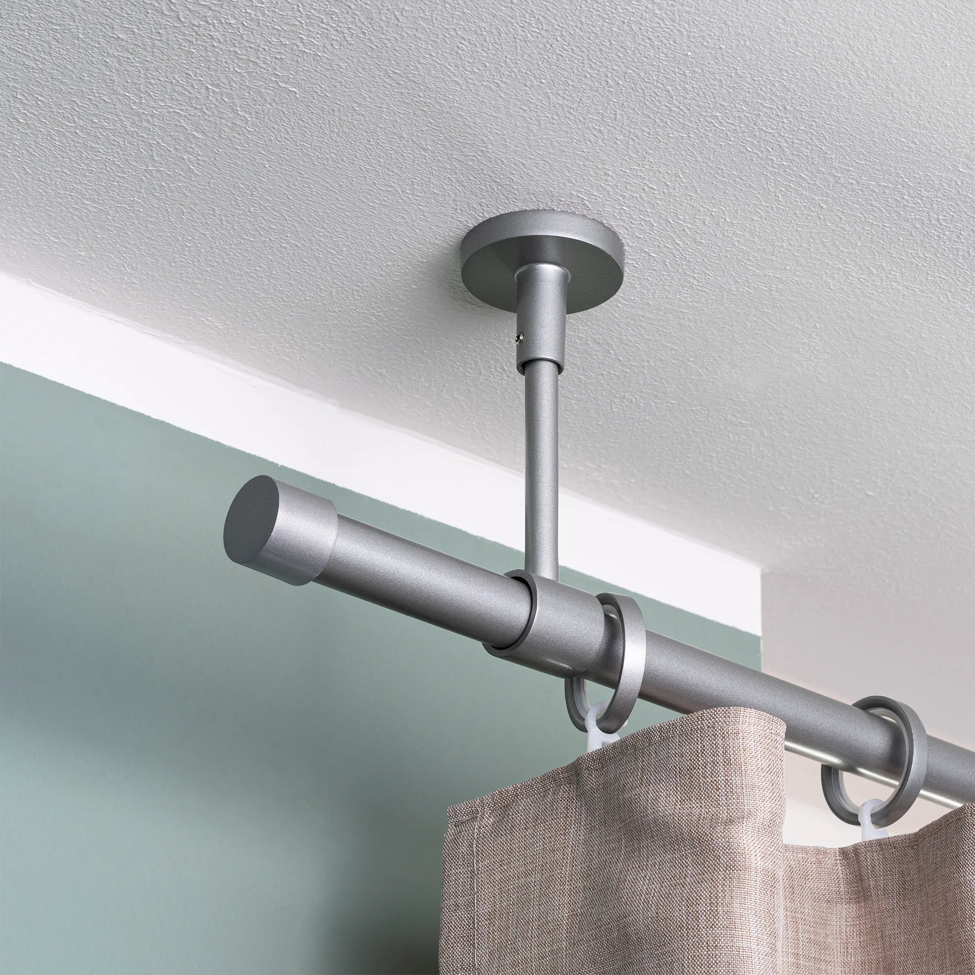 Asta per tende montata a soffitto con anelli e tenda appesa