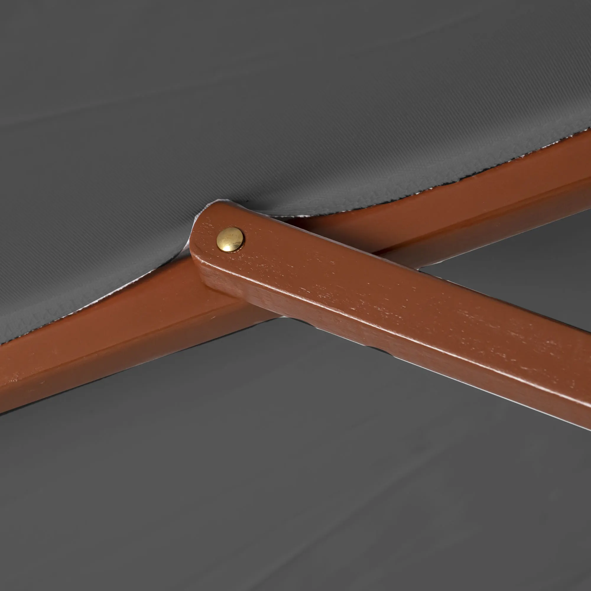 Primo piano di un ombrellone in legno pieghevole con giunto visibile e rivestimento in tessuto