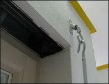 Cerniera della porta con gancio montata su una parete, mostra il meccanismo di fissaggio.