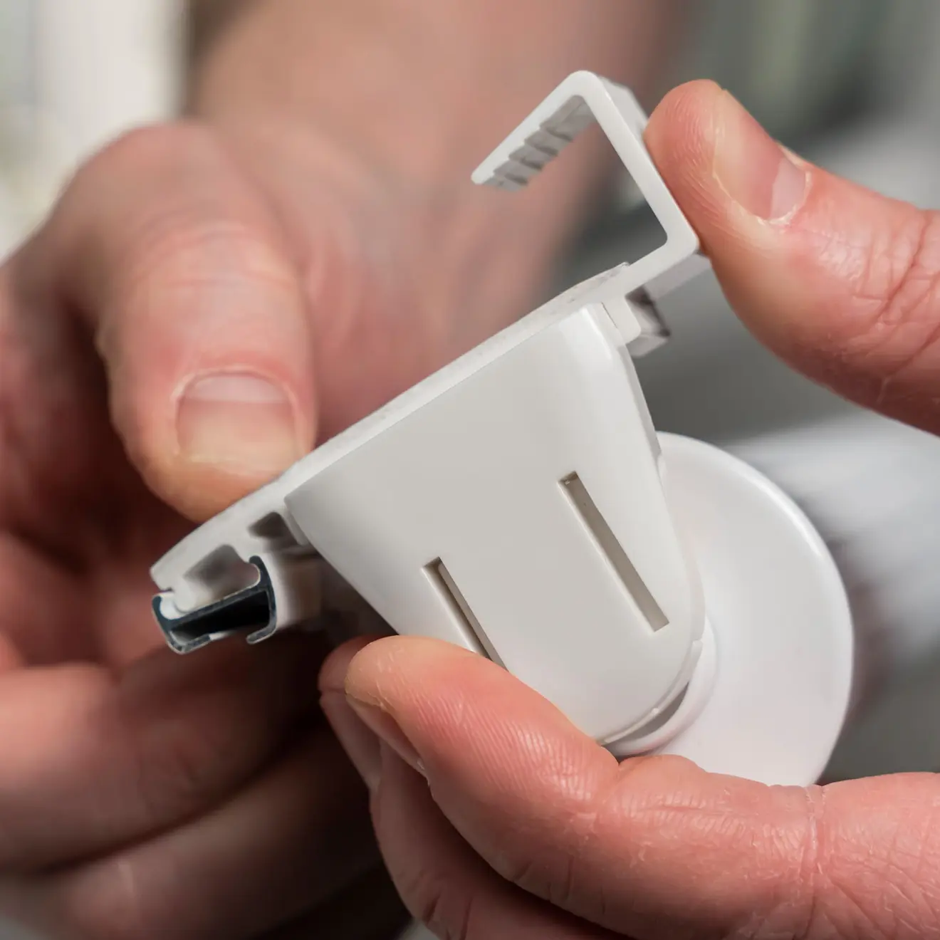 Nahaufnahme einer Hand, die ein Klemmfix Doppelrollo mit Halterung hält