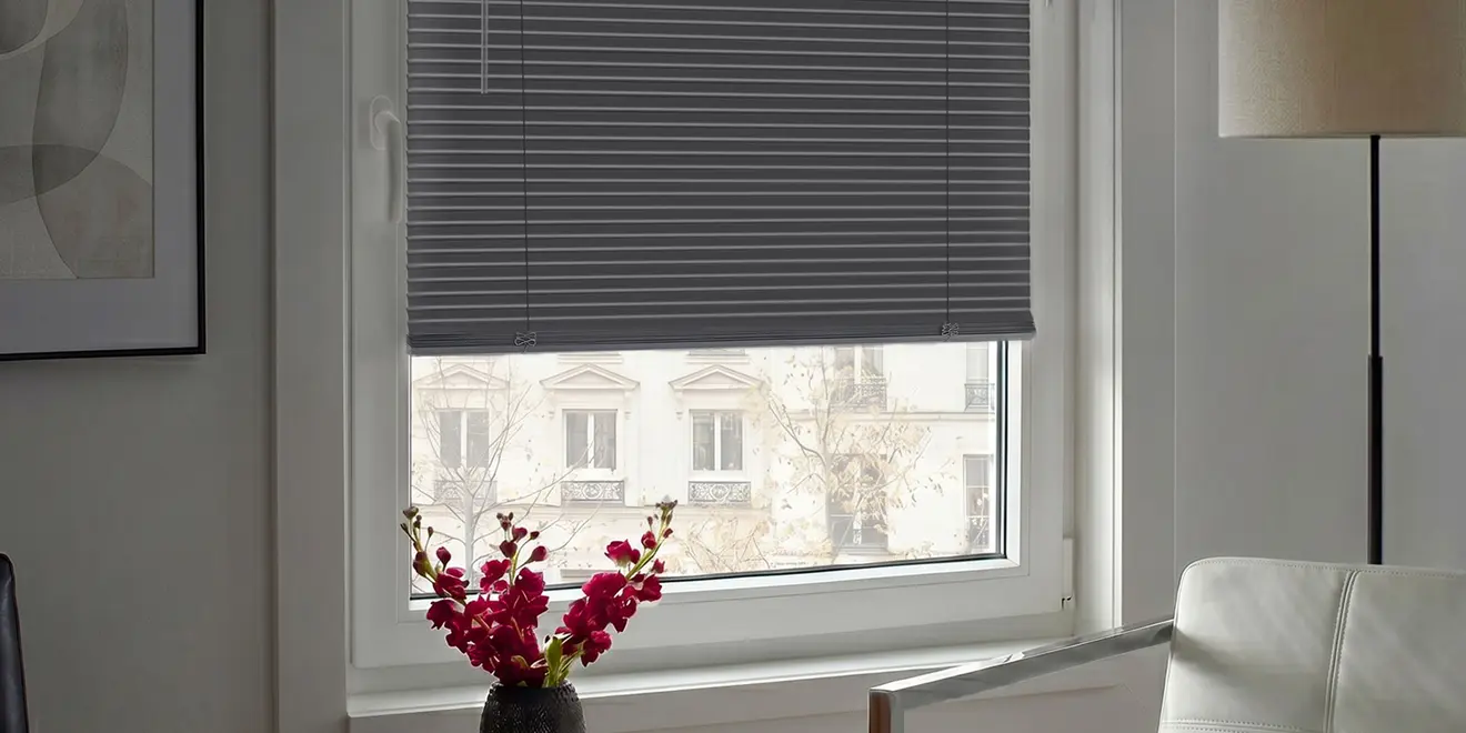 Fenster mit halb geschlossenem Rollo und Blick auf Häuserfassaden