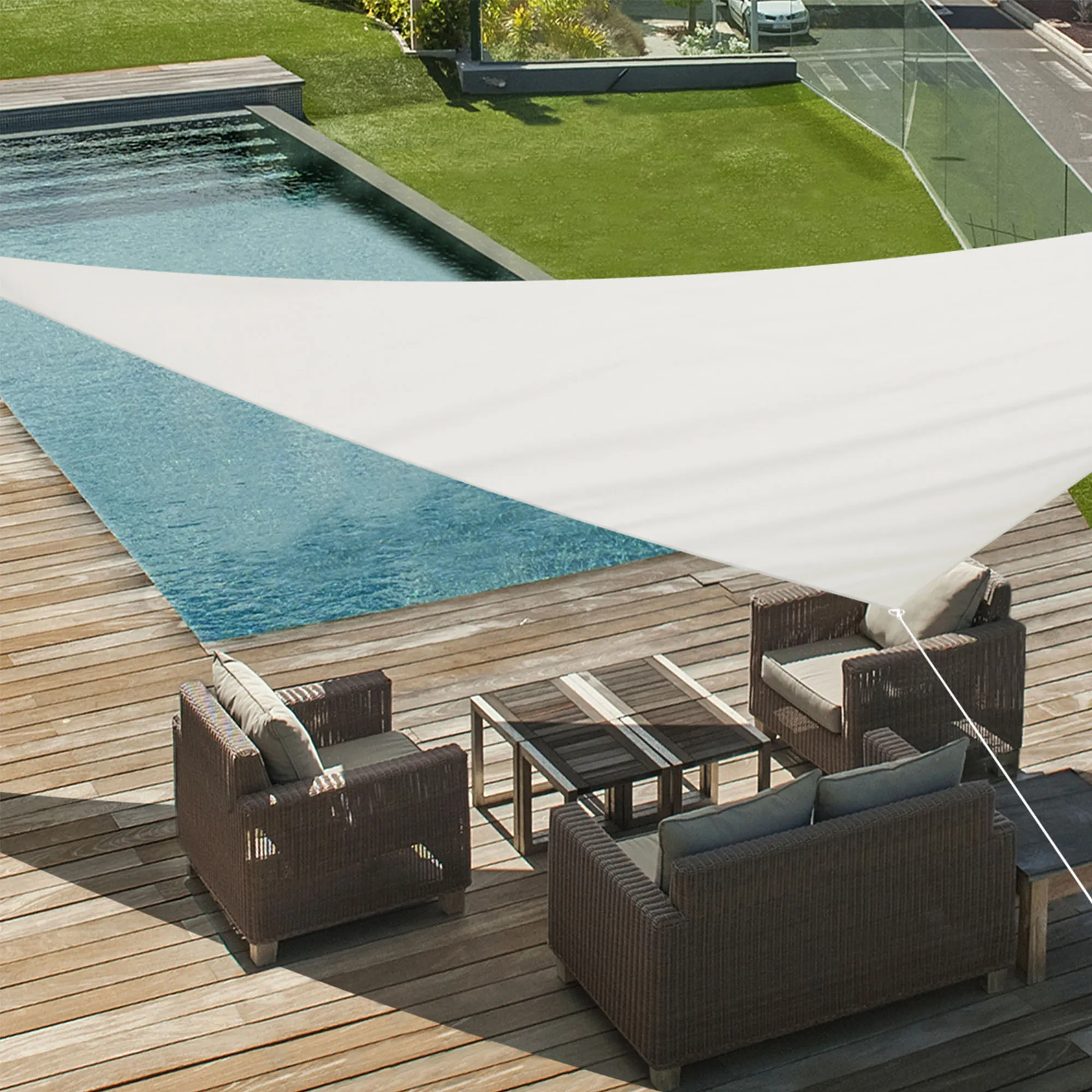 Telo da sole sopra una terrazza con area salotto e piscina sullo sfondo