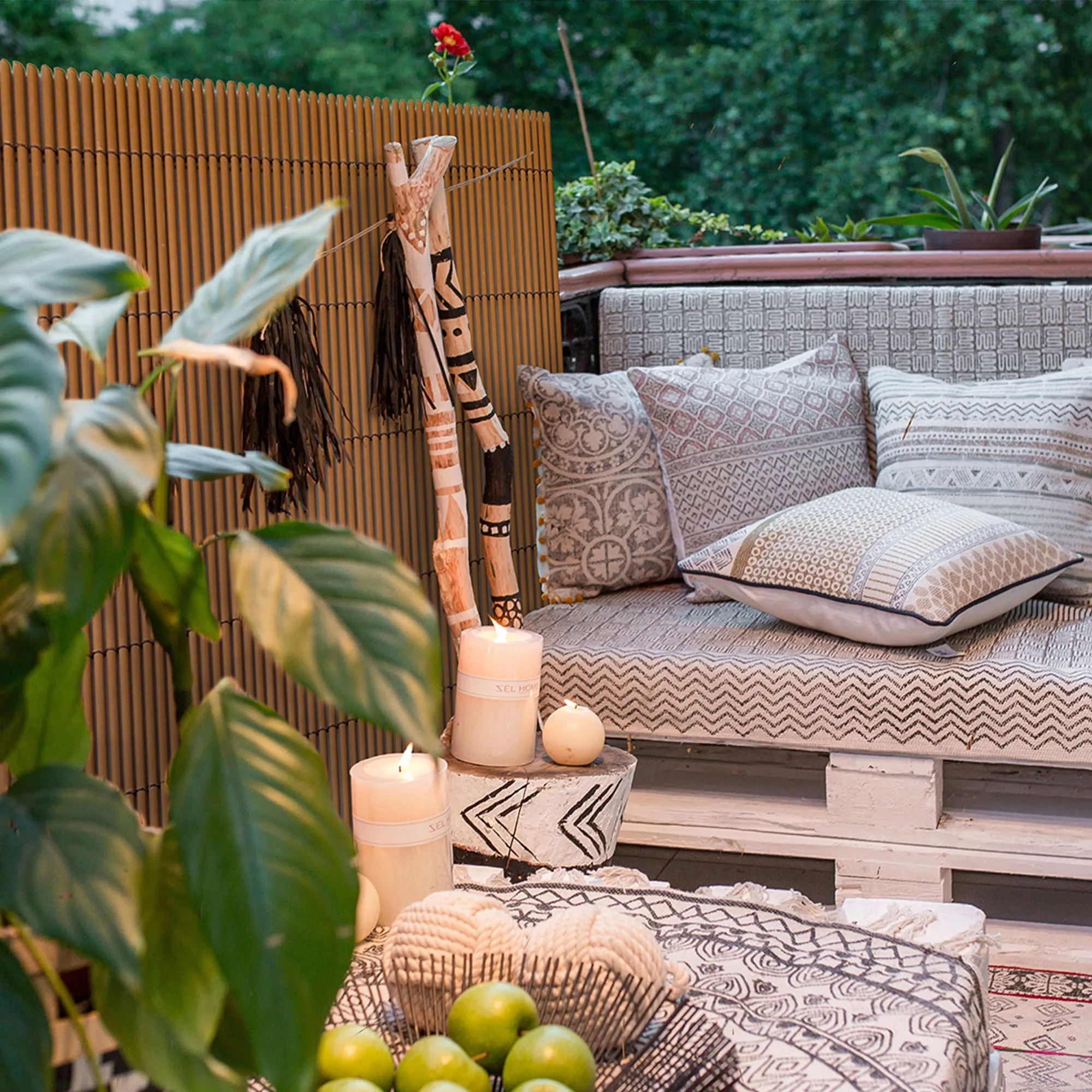 Terrazza con pannello di protezione, area salotto, cuscini, piante e decorazioni
