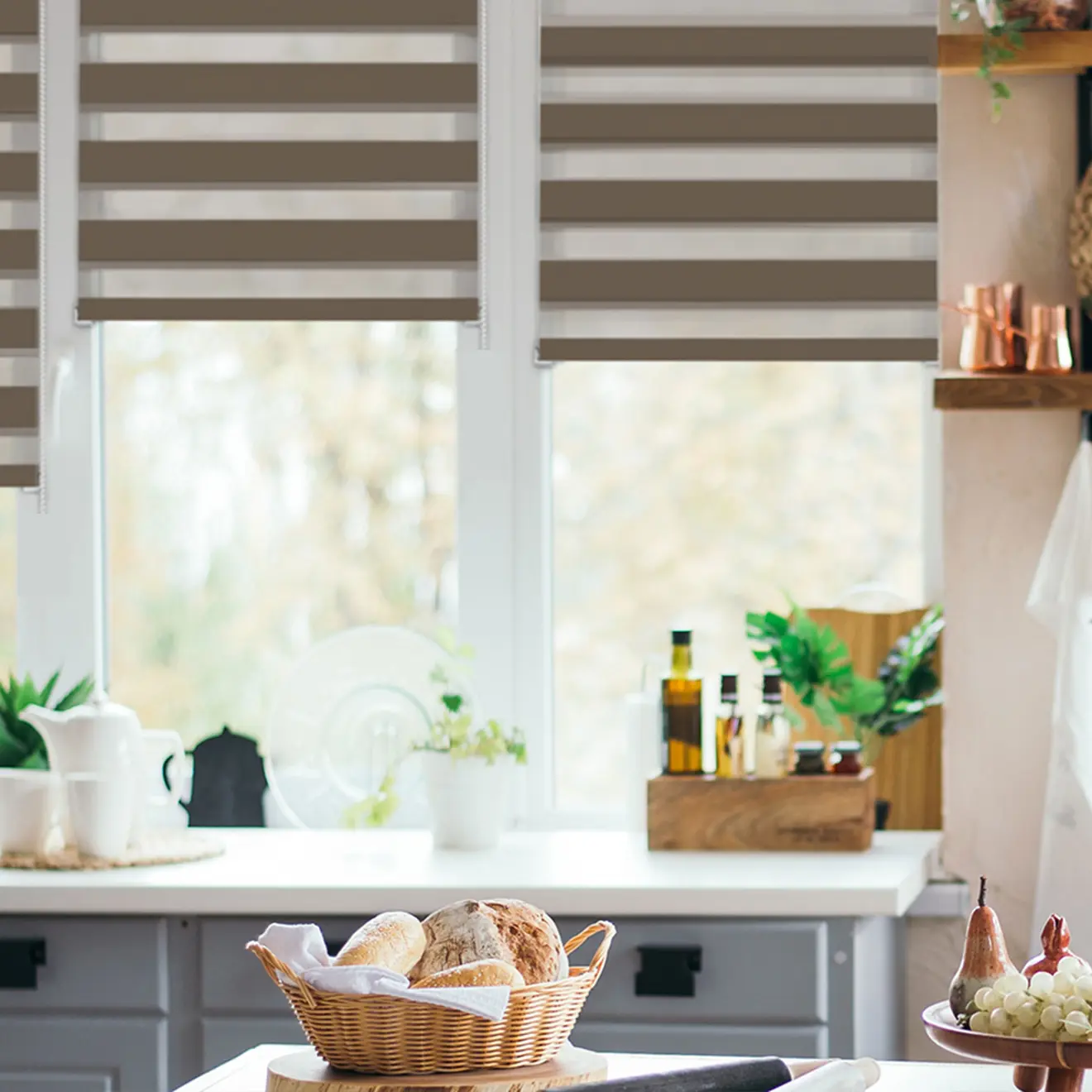 Elektrisches Smart Doppelrollo in Küche, halb geschlossen, vor Fenster mit Pflanzen und Küchenutensilien