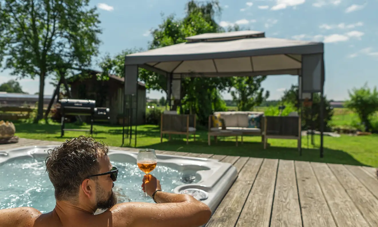 Gartenpavillon mit Ersatzdach neben Whirlpool auf Holzterrasse im Freien