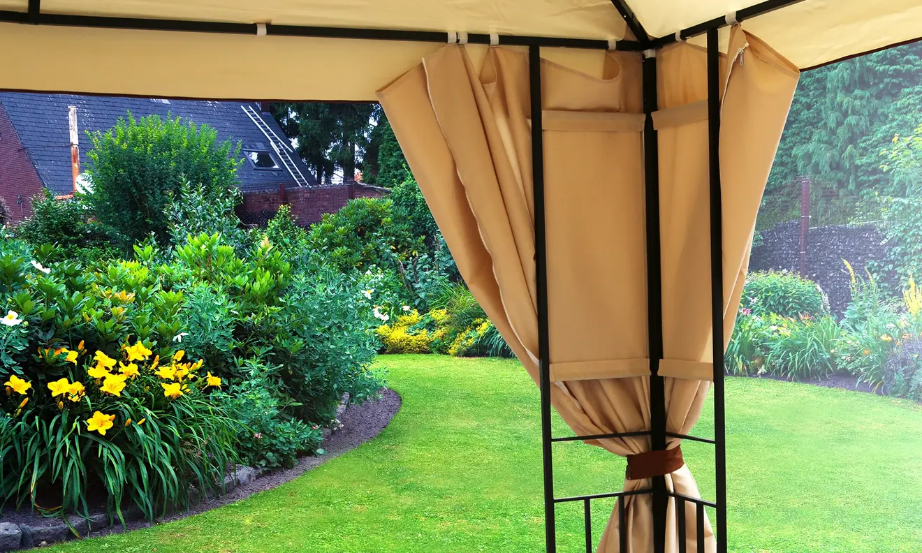 Gartenpavillon mit Vorhängen, Blick auf gepflegten Garten im Hintergrund
