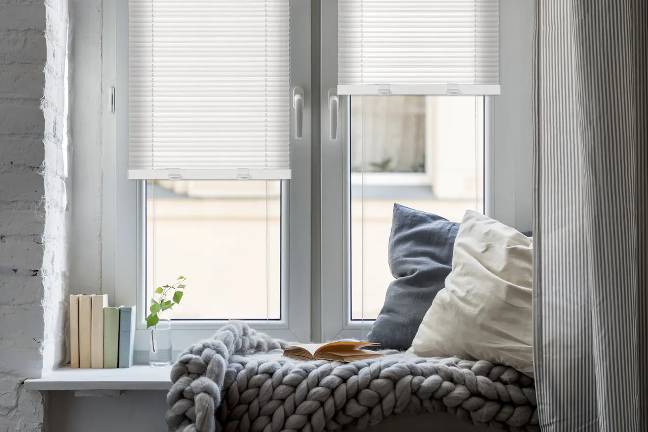 Fenster mit EasyFix Plissee und Klemmhalter, dekoriert mit Kissen und Büchern auf der Fensterbank