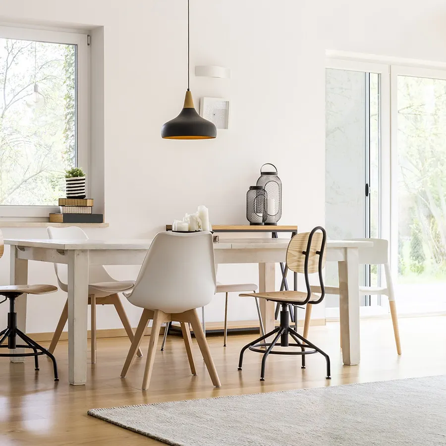 Zona pranzo con tavolo, sedie e porta zanzariera sullo sfondo