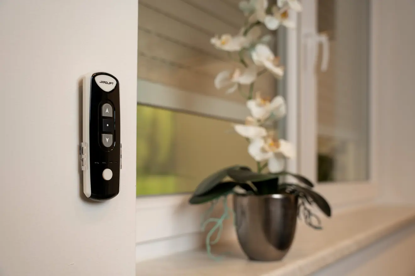 JAROLIFT Funkhandsender an Wand neben Fenster mit Rollladen