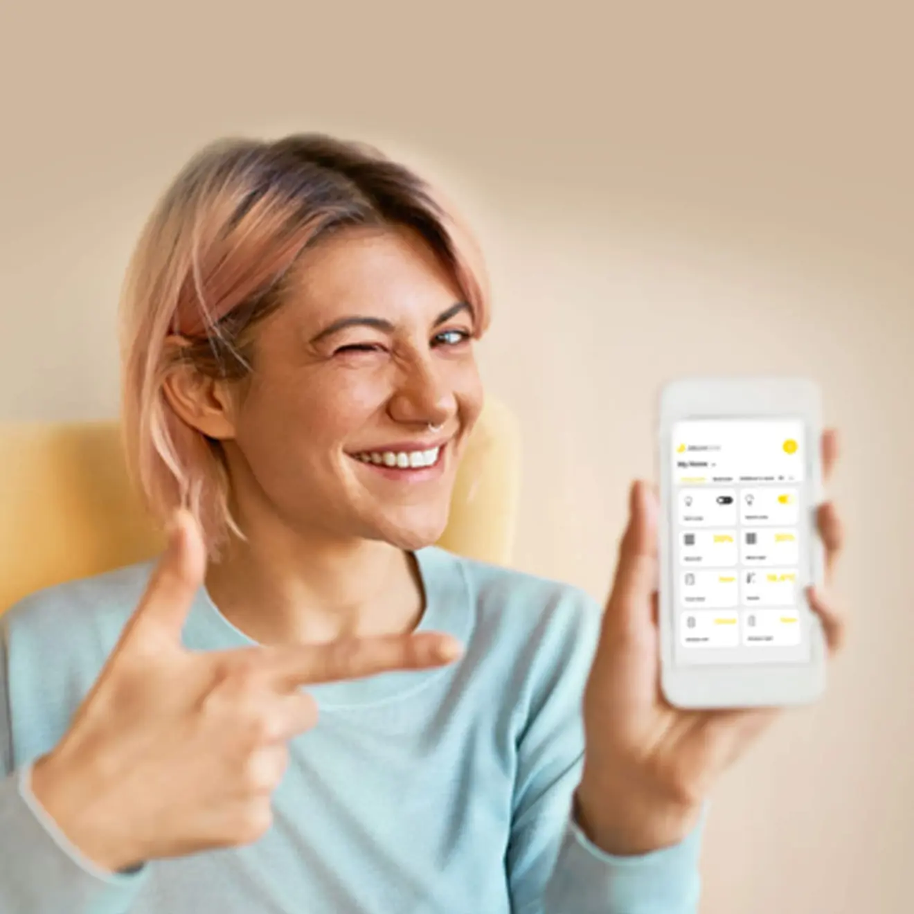 Person hält Smartphone mit Smart-Home-App, lächelt und zeigt auf das Display
