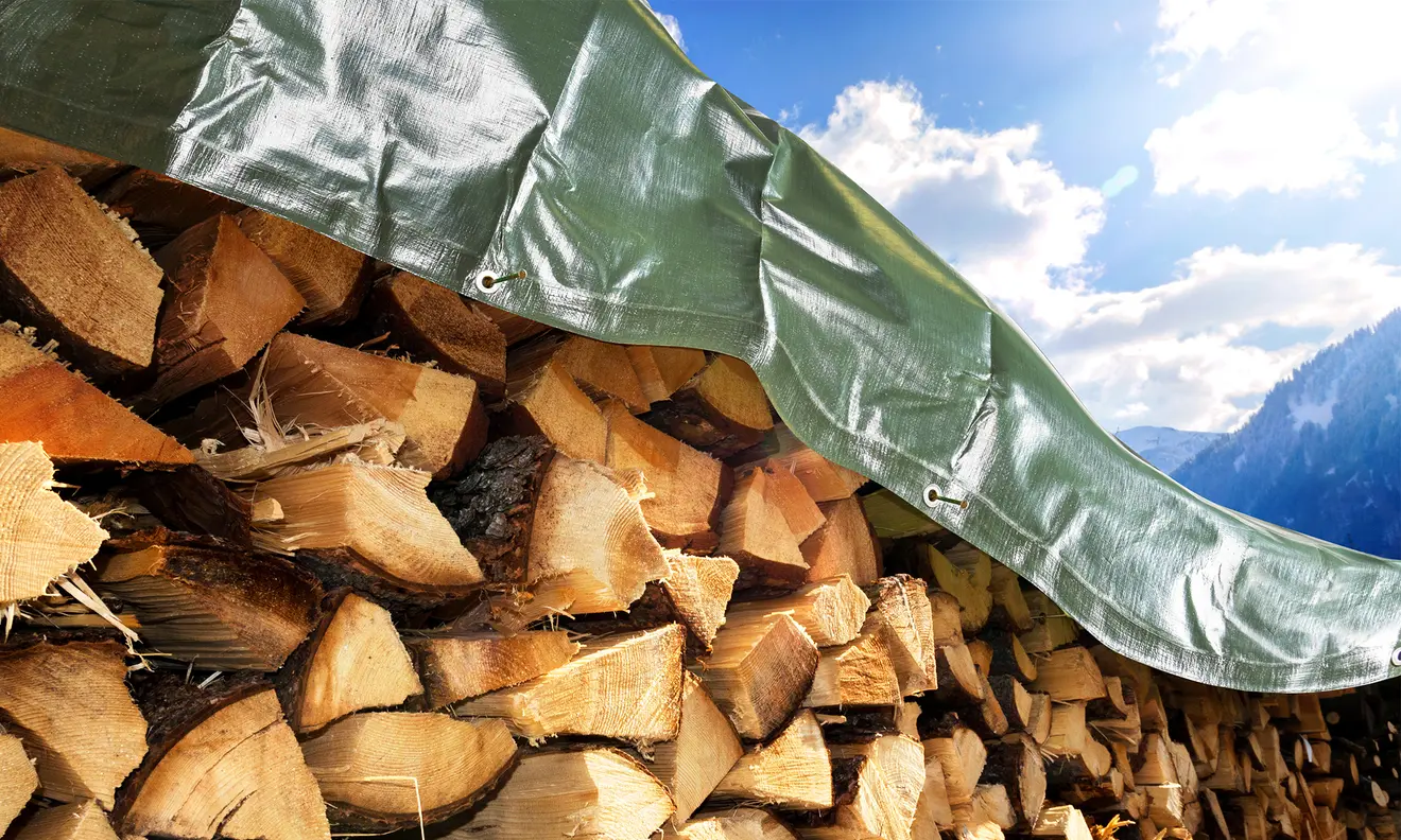 Holzstapel zugedeckt mit einer Abdeckplane