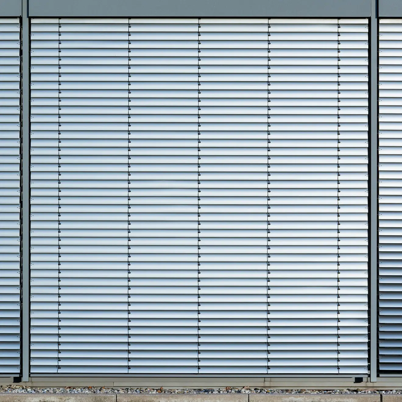 Außenjalousie mit horizontalen Lamellen, montiert an einem Gebäude, zur Lichtregulierung
