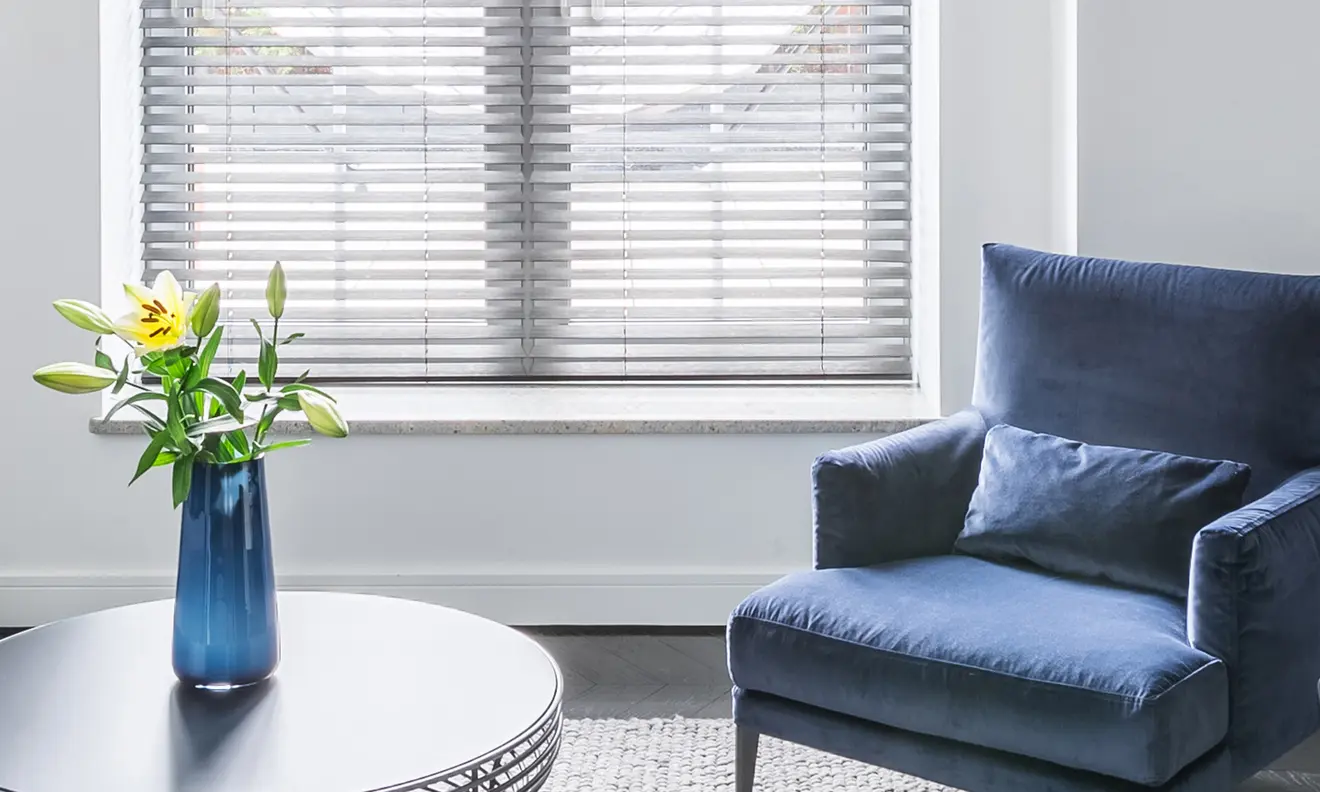Geöffnete Jalousie mit Blumenstrauß und Sofa