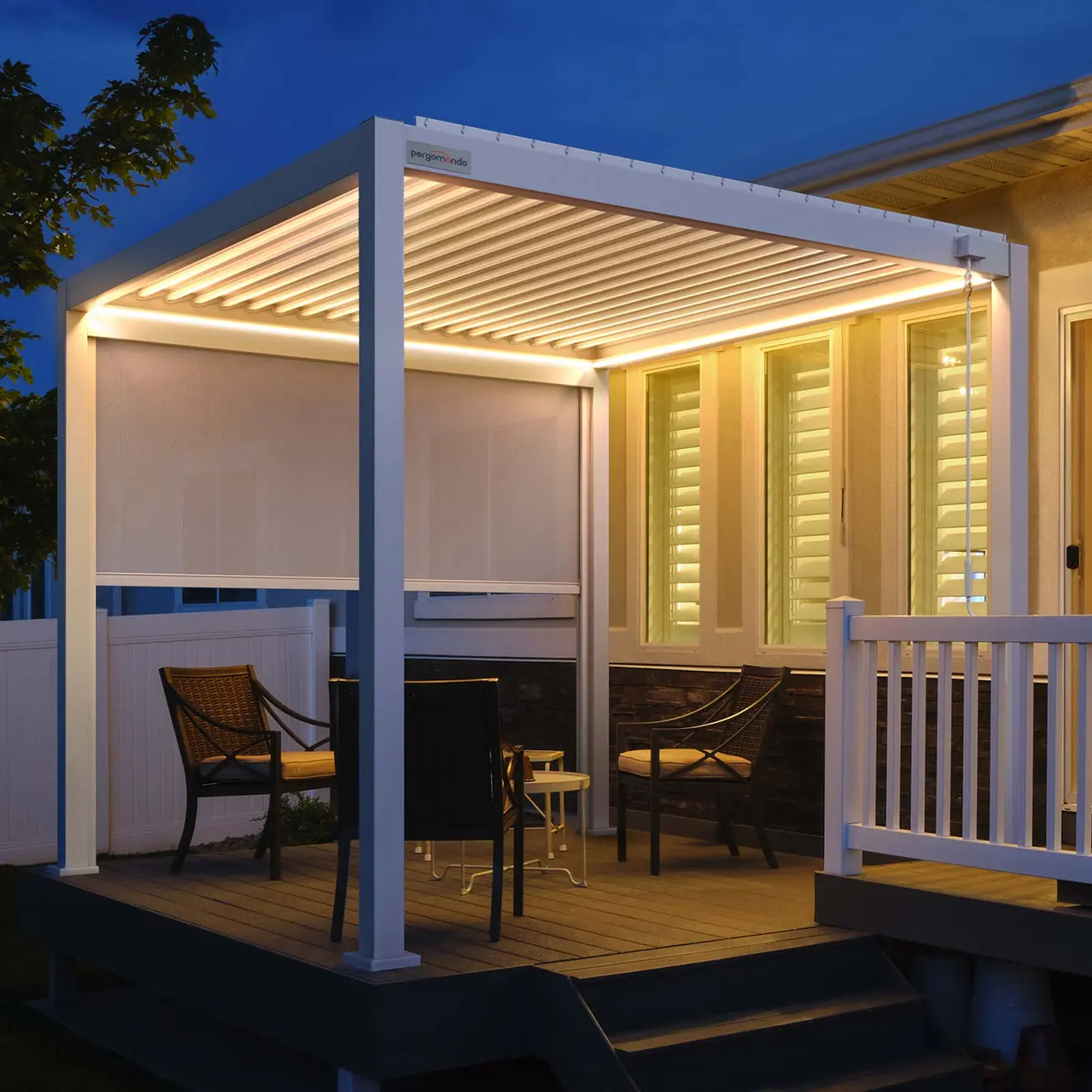 Pergola mit Lamellendach auf Terrasse, umgeben von Stühlen und Tisch, beleuchtet bei Nacht