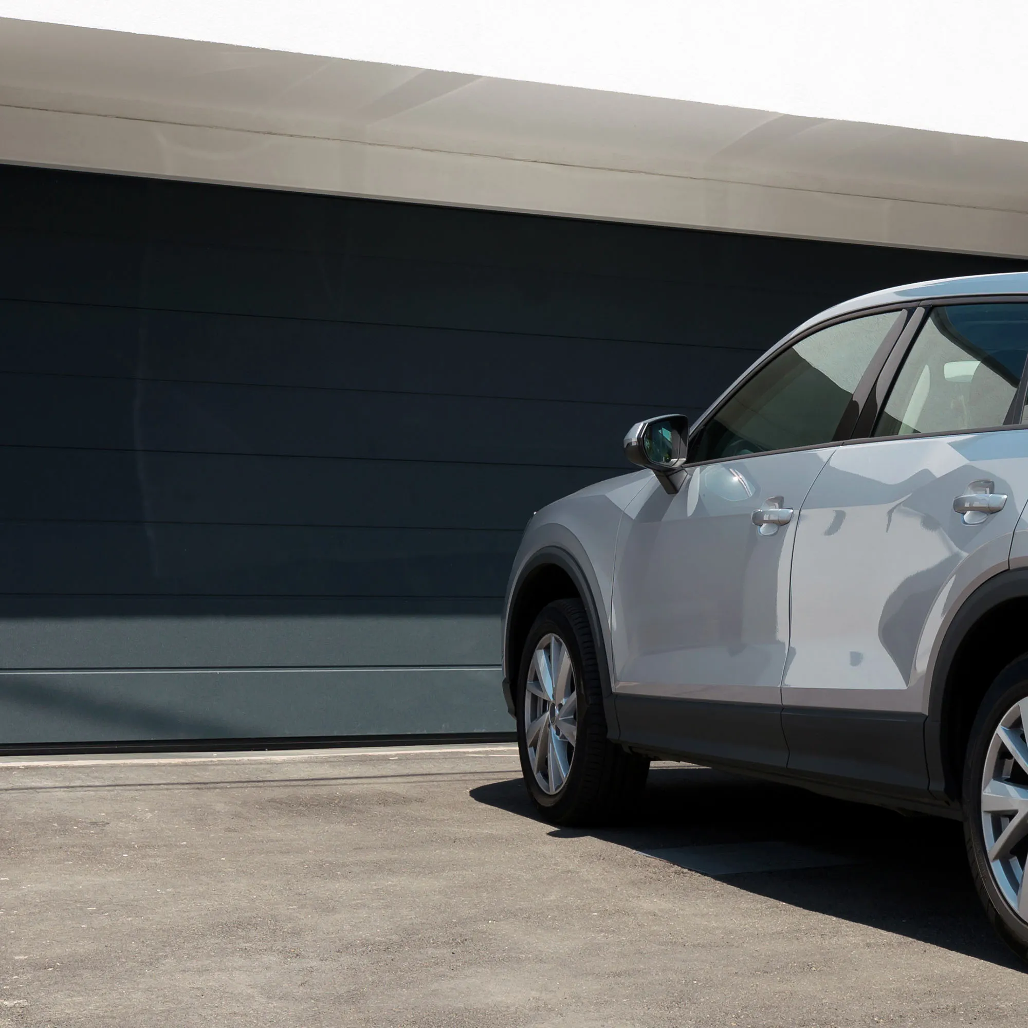 Auto davanti a garage chiuso, nessun supporto per parasole visibile