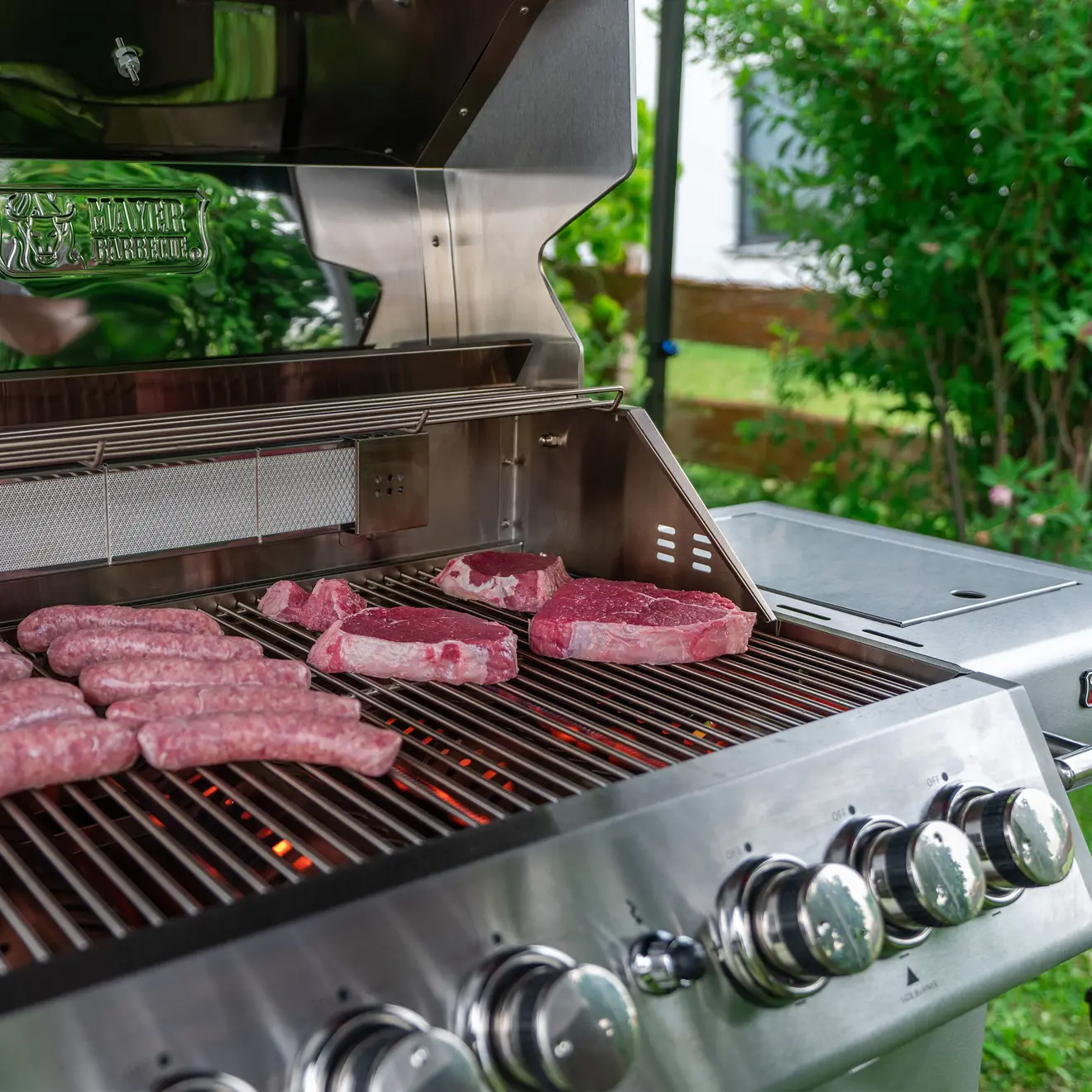 Detailbild von einem Grillrost mit Fleisch und Würste