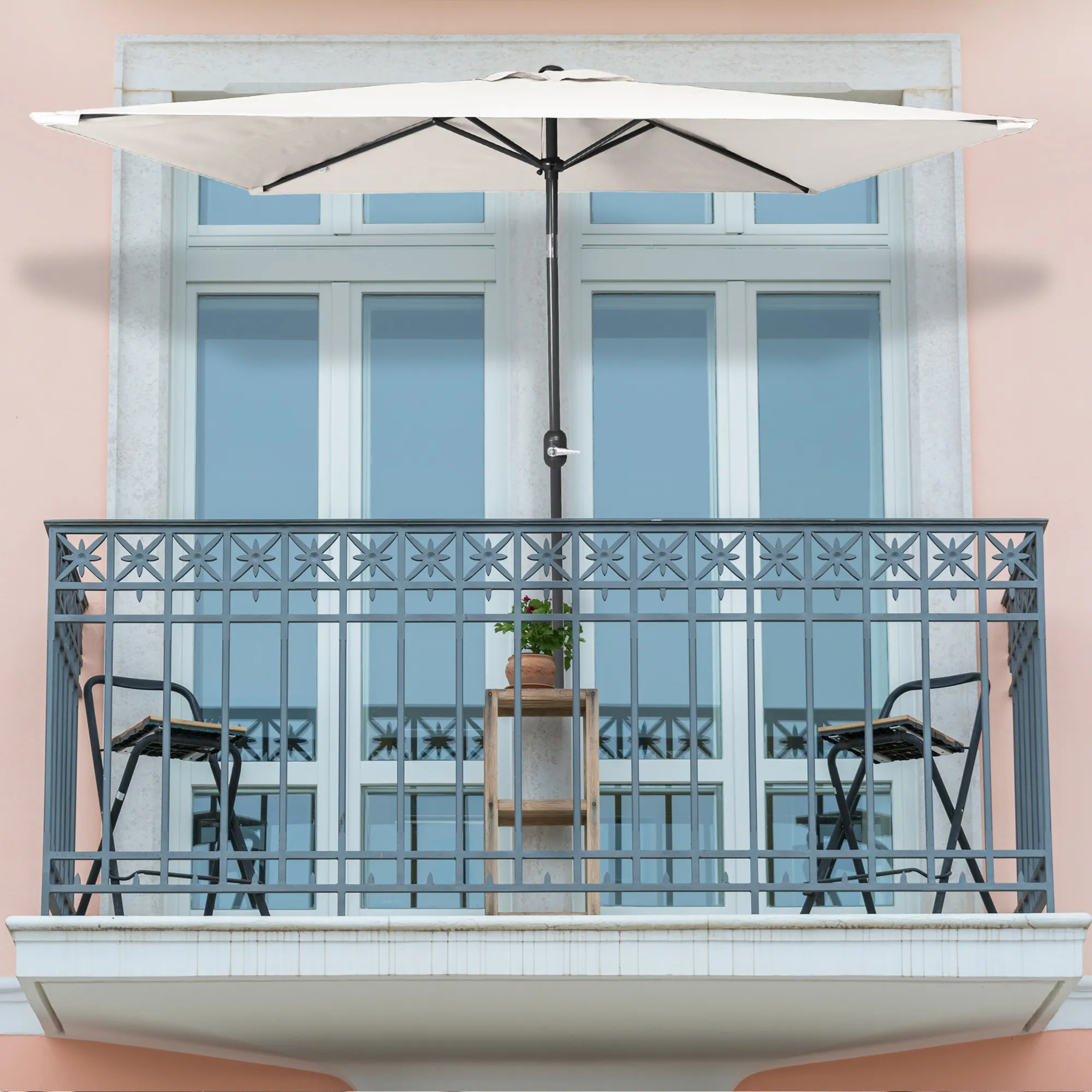 Piccolo ombrellone pieghevole su un balcone sopra un tavolo e sedie