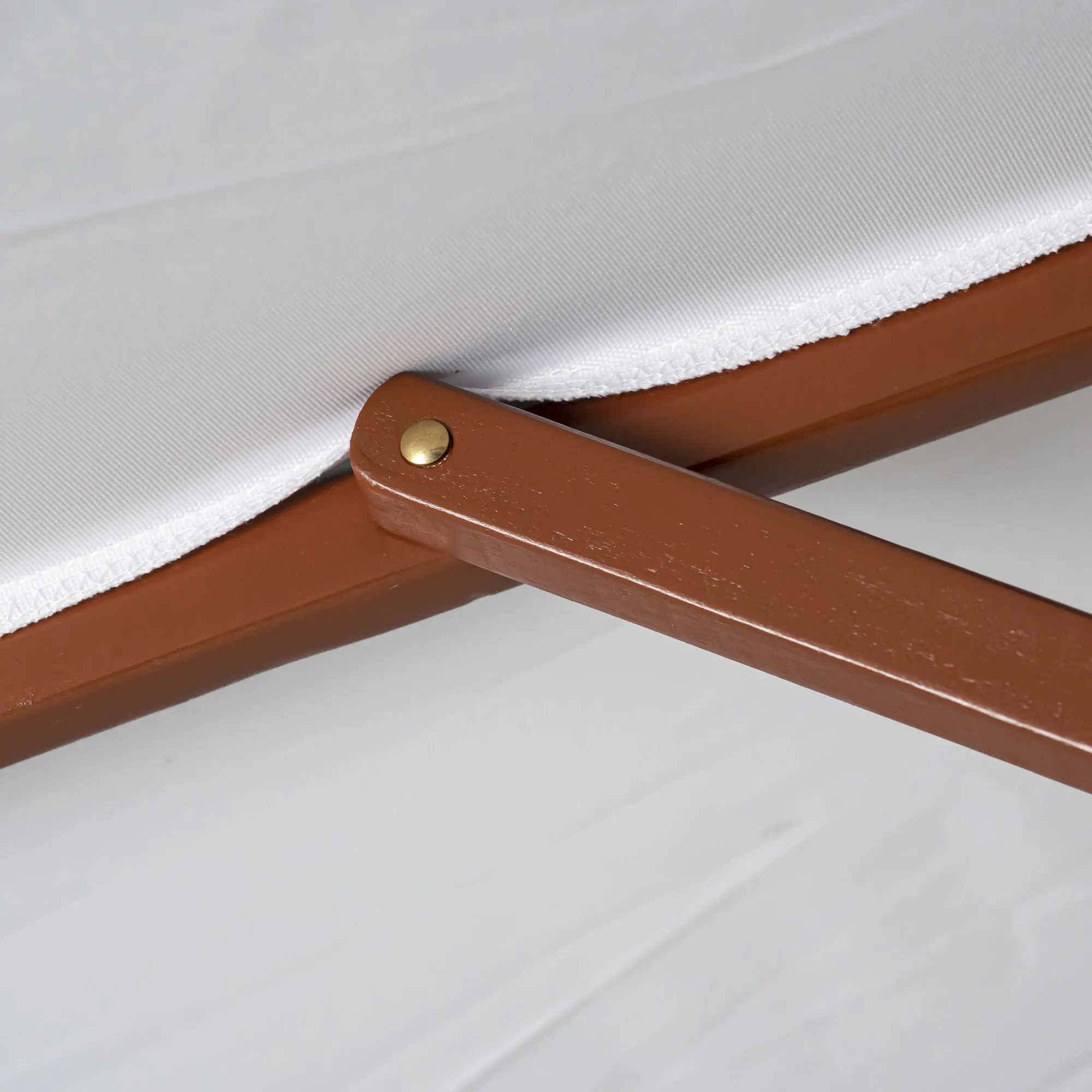 Primo piano di un ombrellone in legno pieghevole con giunto visibile e rivestimento in tessuto