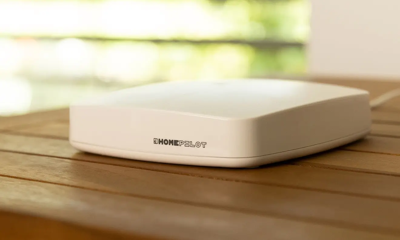 Flaches, rechteckiges Gerät mit abgerundeten Ecken, möglicherweise ein Gateway oder Router