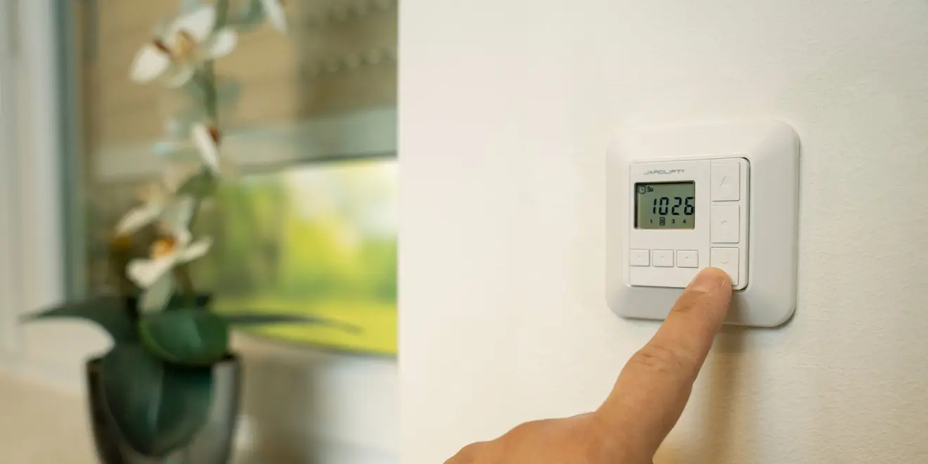 Funk-Wandsender TDRC an der Wand wird gerade mit einem einem Finger bedient