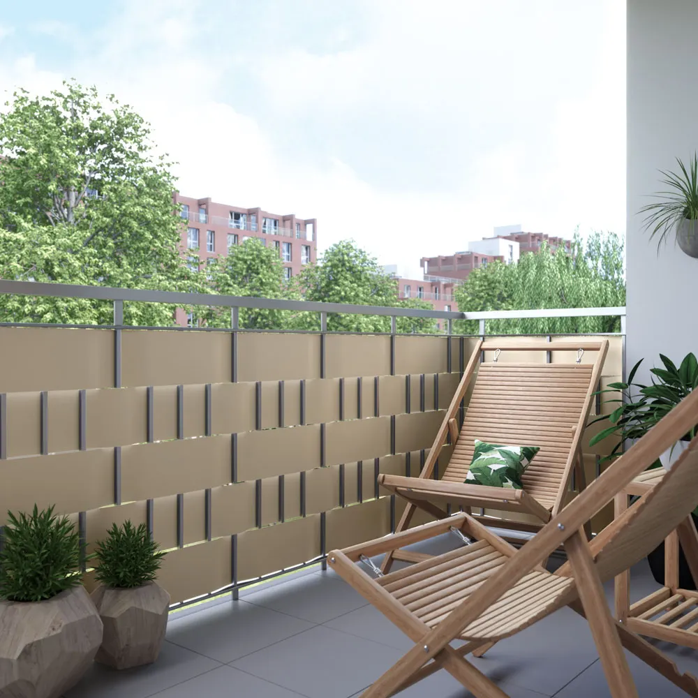 Balcone con strisce di protezione in PVC e clip di fissaggio, due sedie in legno, piante sullo sfondo