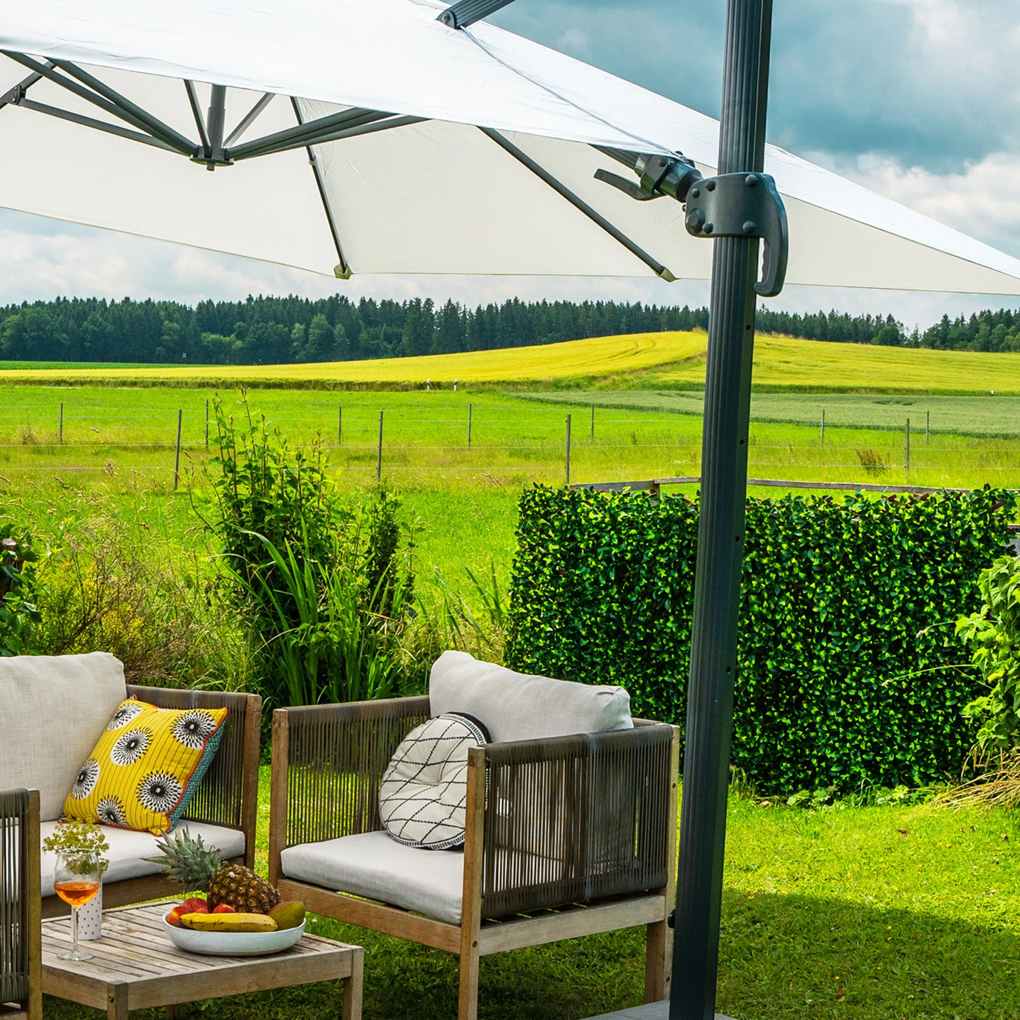 Persona rilassata in una vasca idromassaggio, parete di piante artificiali sullo sfondo, ambiente da giardino