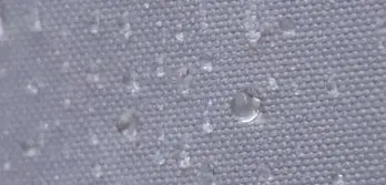 Nahaufnahme eines wasserabweisenden Stoffes des Faltpavillons PRO mit Wassertropfen auf der Oberfläche