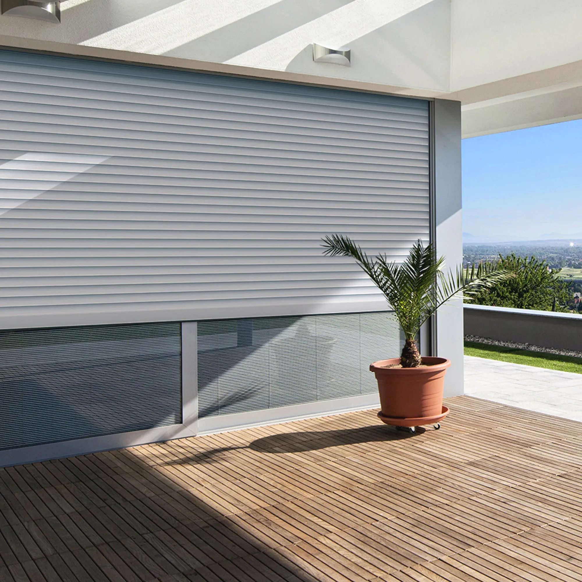 Persiana con isolamento su una finestra, terrazza con pianta in primo piano