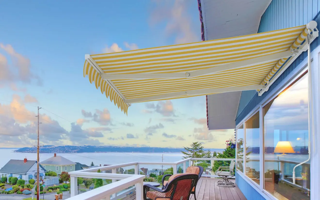 Markisenkurbel starr neben einer Terrasse mit Blick auf das Meer und Häuser im Hintergrund