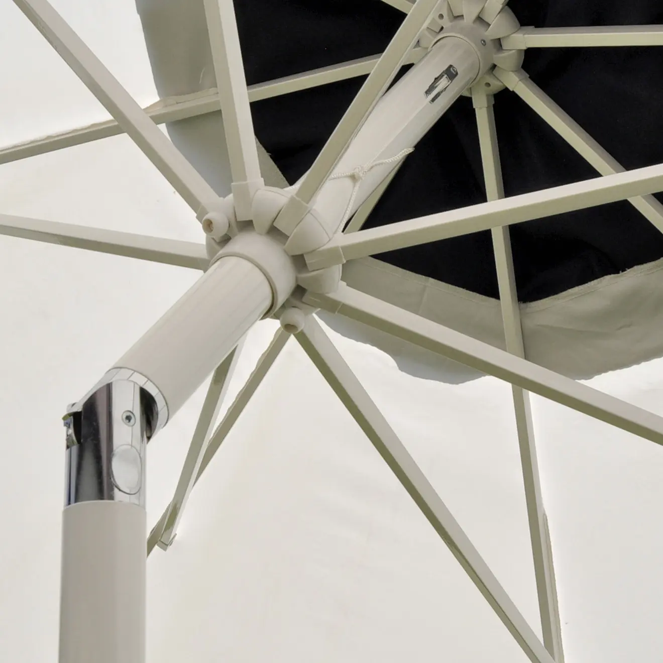 Detail eines Sonnenschirms von unten mit Streben und Mittelstange