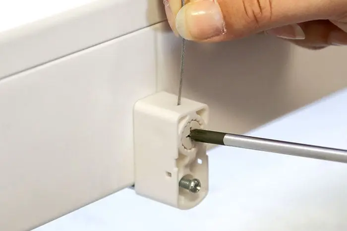 Hand montiert Klemmhalter für EasyFix Plissees an einer Oberfläche mit Schraubendreher